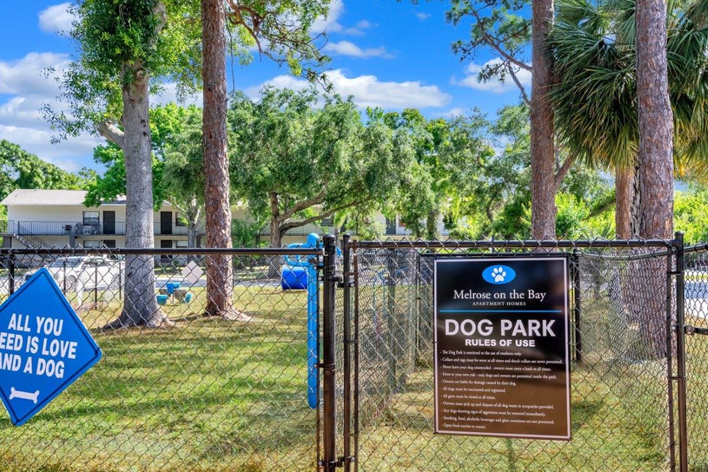 a dog park with a sign that says dog park belongs to a dog