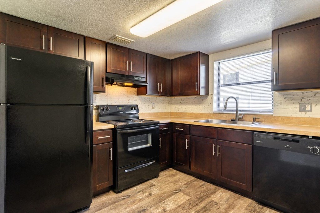 a kitchen with black appliances and wooden cabinets