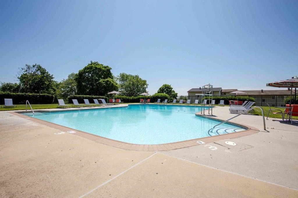 a swimming pool at a hotel with chairs around it
