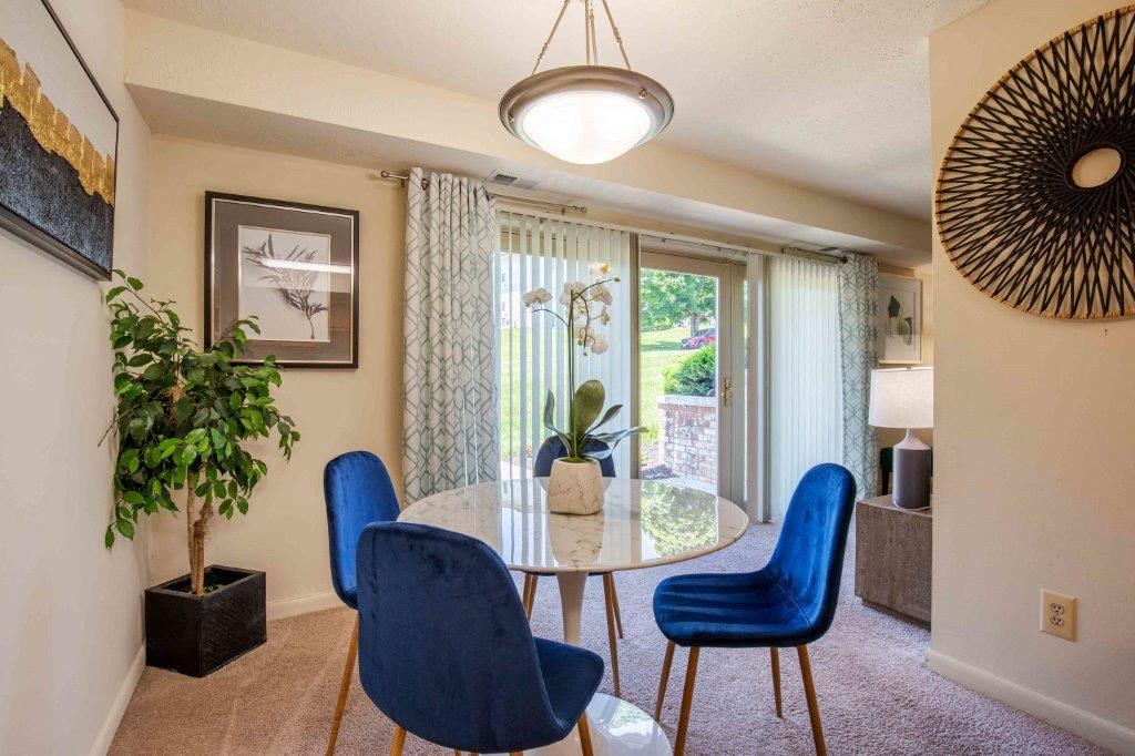 a dining room with a table and chairs and a window