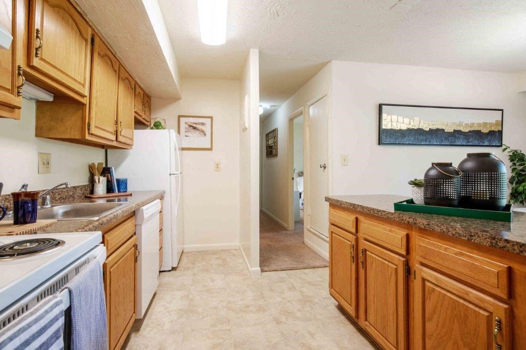 a kitchen with wooden cabinets and a sink and a refrigerator