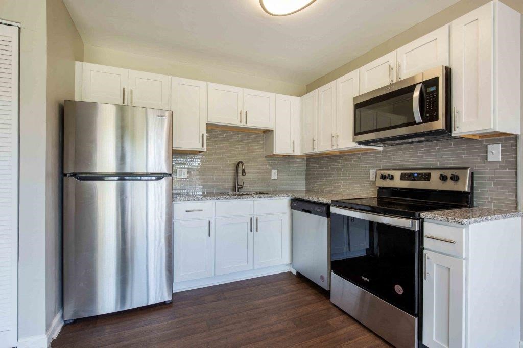 a kitchen with stainless steel appliances and white cabinets