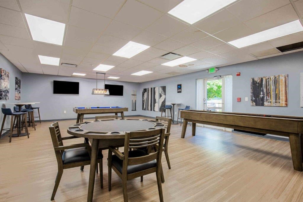 a game room with tables and chairs and a pool table