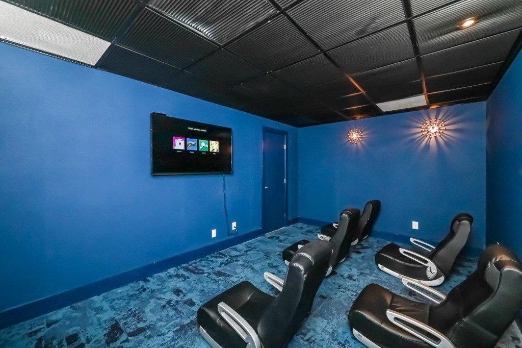 a blue screening room with chairs and a television