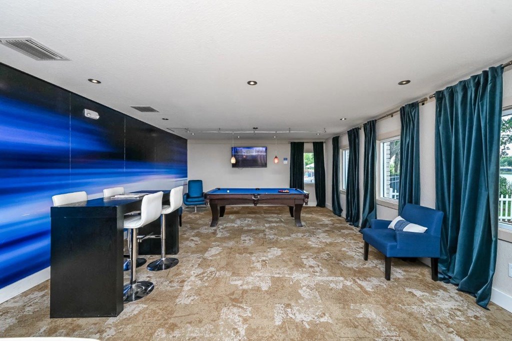a game room with a pool table and a bar