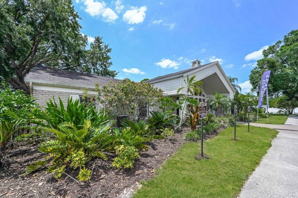 a white house with a garden in front of it