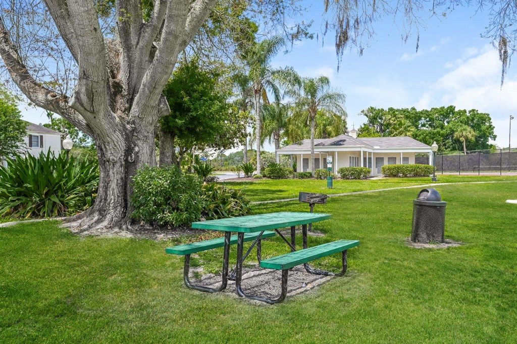 a picnic table in a park next to a tree