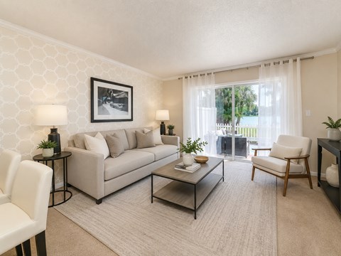 A living room with a grey couch, a coffee table, and a painting on the wall.