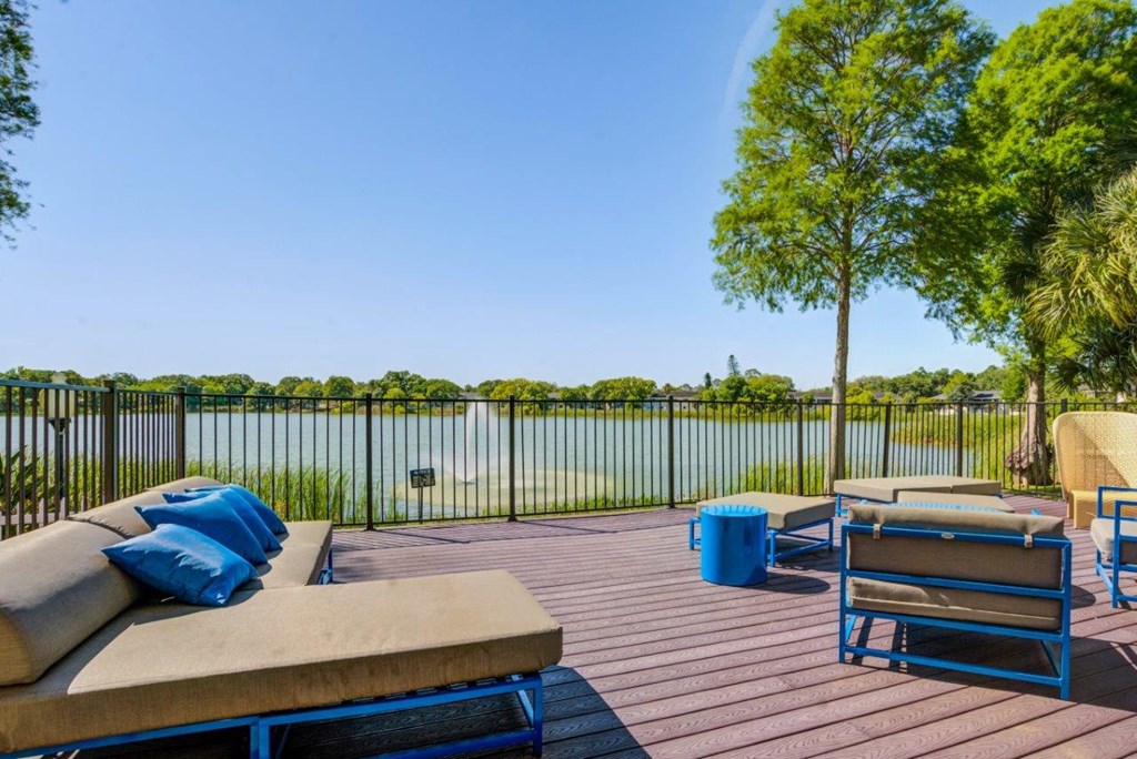 a patio with couches and chairs overlooking a body of water