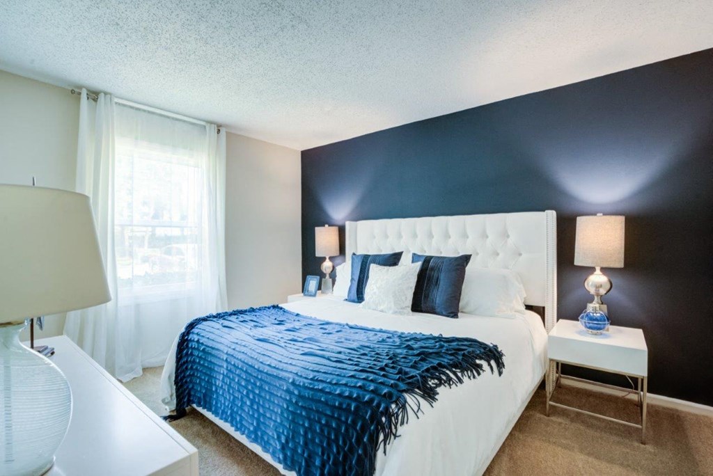a bedroom with a white bed and a blue accent wall