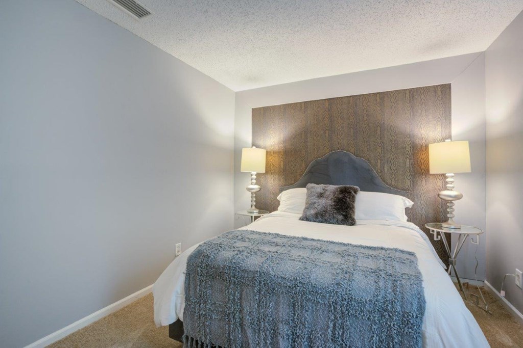 a bedroom with a bed and two lamps