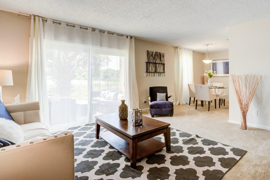 a living room and dining room with a large window and a table