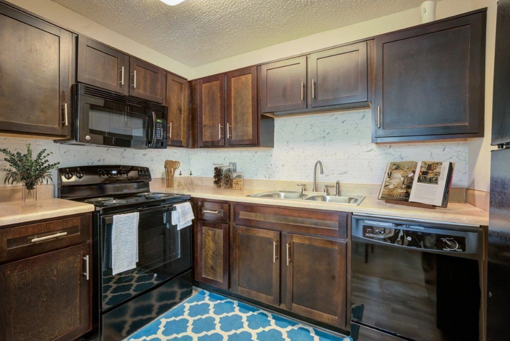 a kitchen with black appliances and wooden cabinets