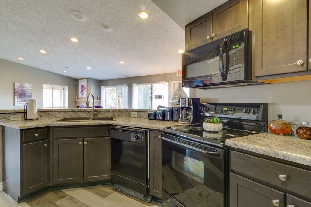 the kitchen has stainless steel appliances and granite counter tops