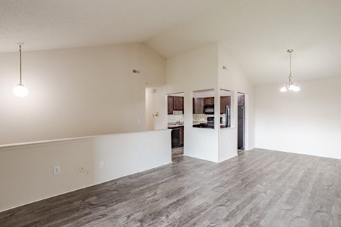 A spacious room with a kitchen area in the background.