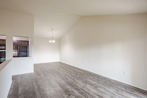 A large empty room with a grey floor and white walls.