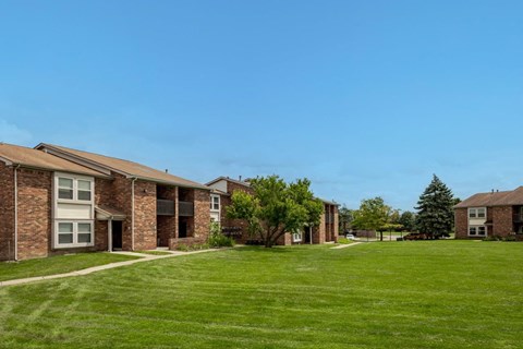 A row of houses with green lawns in front.