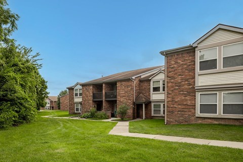 A row of houses with green lawns in front.