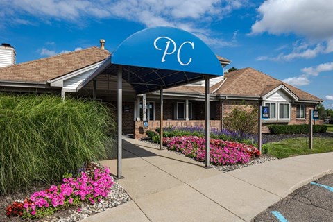 A blue canopy with the letters "PC" on it is in front of a building.