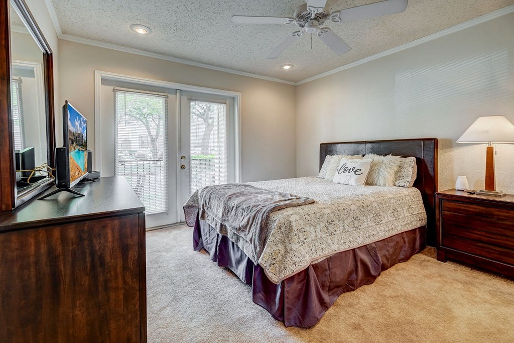 the master bedroom has a king sized bed and access to the patio