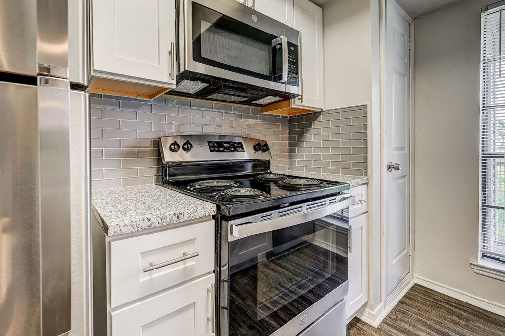 an empty kitchen with a stove and a microwave