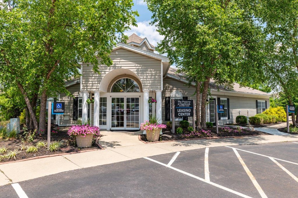 the front of our building with parking lot and trees