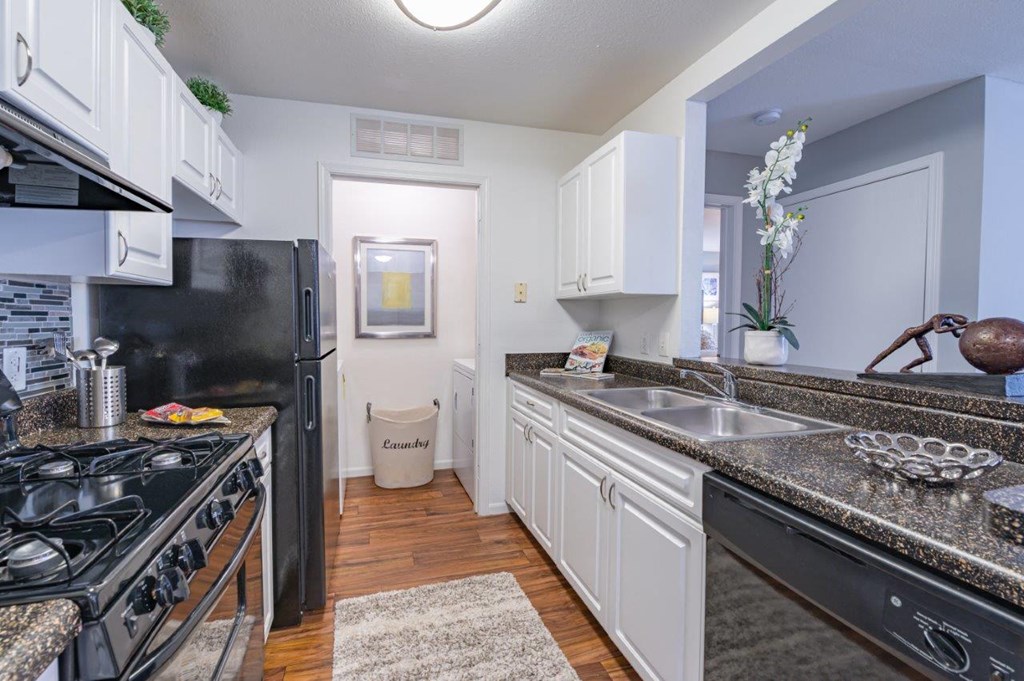 a kitchen with granite counter tops and black appliances
