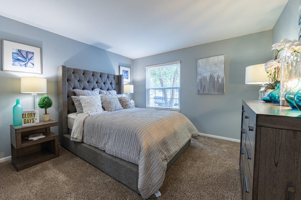 a bedroom with a bed and a dresser and a window