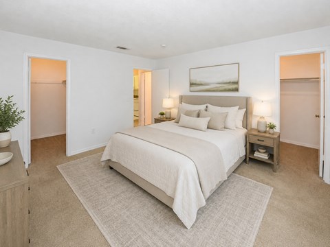 A bedroom with a large bed and a painting on the wall.