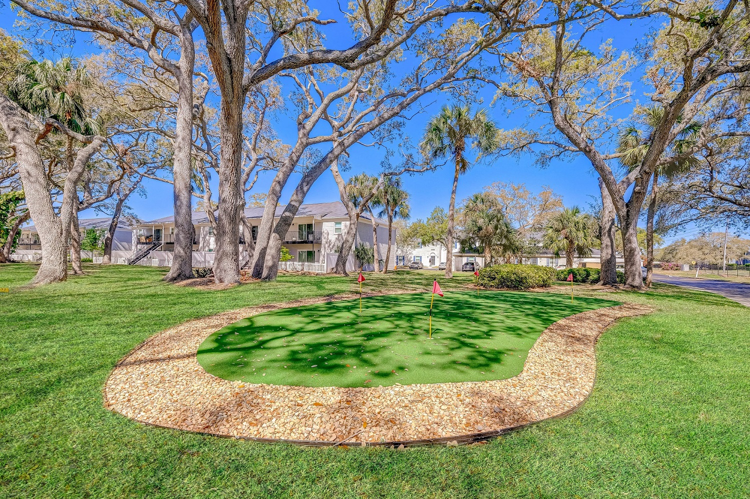 the circle of grass in the center of a park with trees