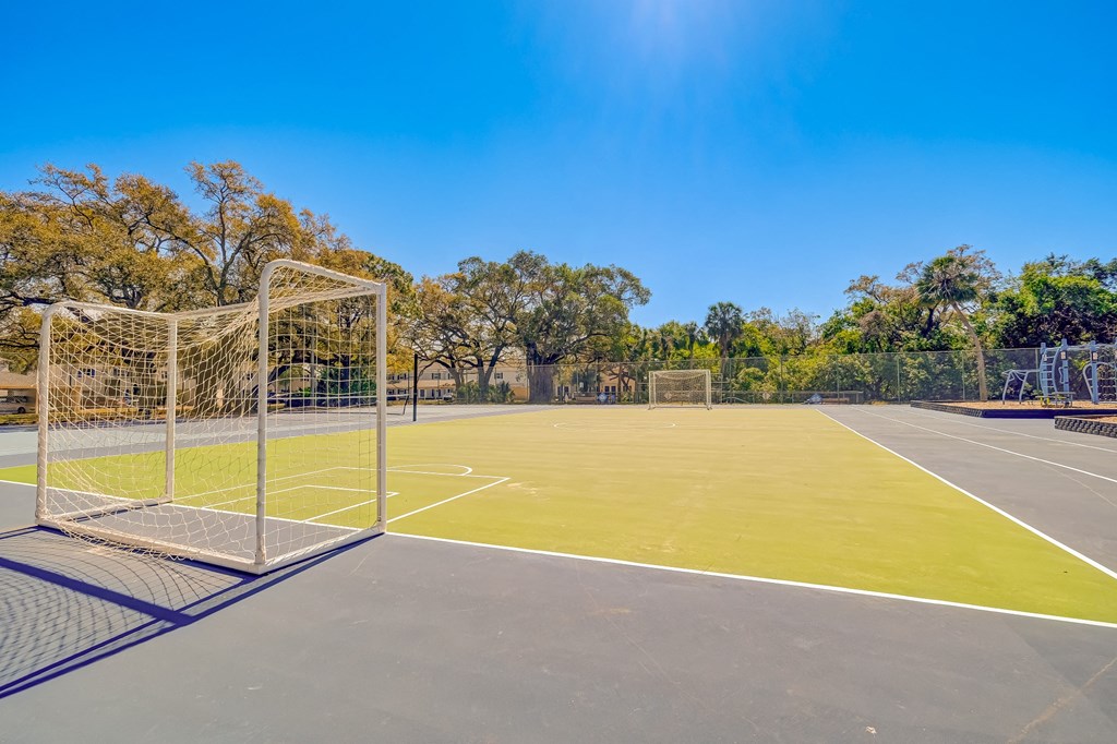 a tennis court with a net and a soccer field