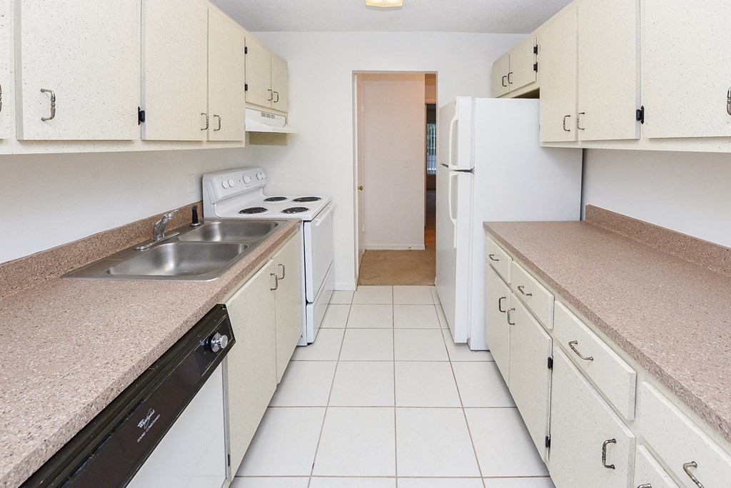 a kitchen with white appliances and counters and white cabinets