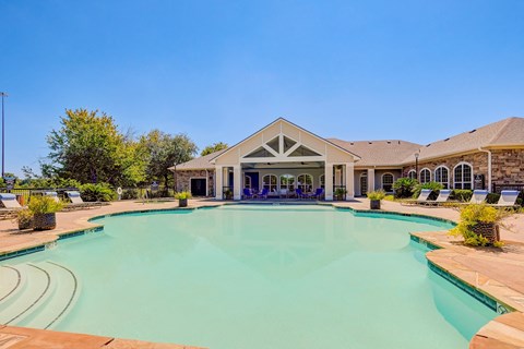 a swimming pool with a house in the background