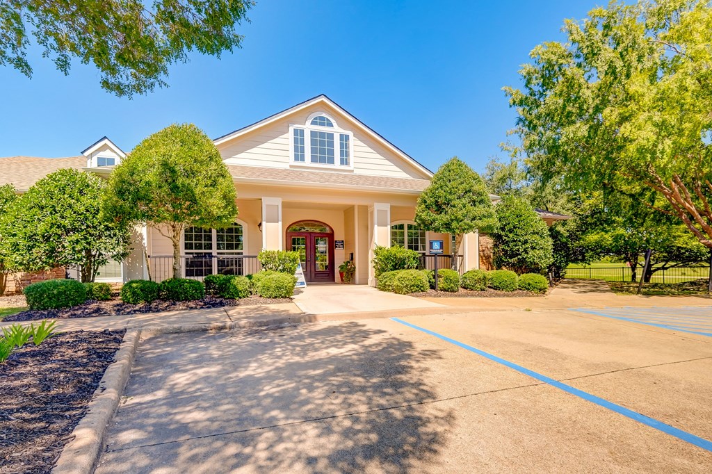 the front of a house with a driveway and trees
