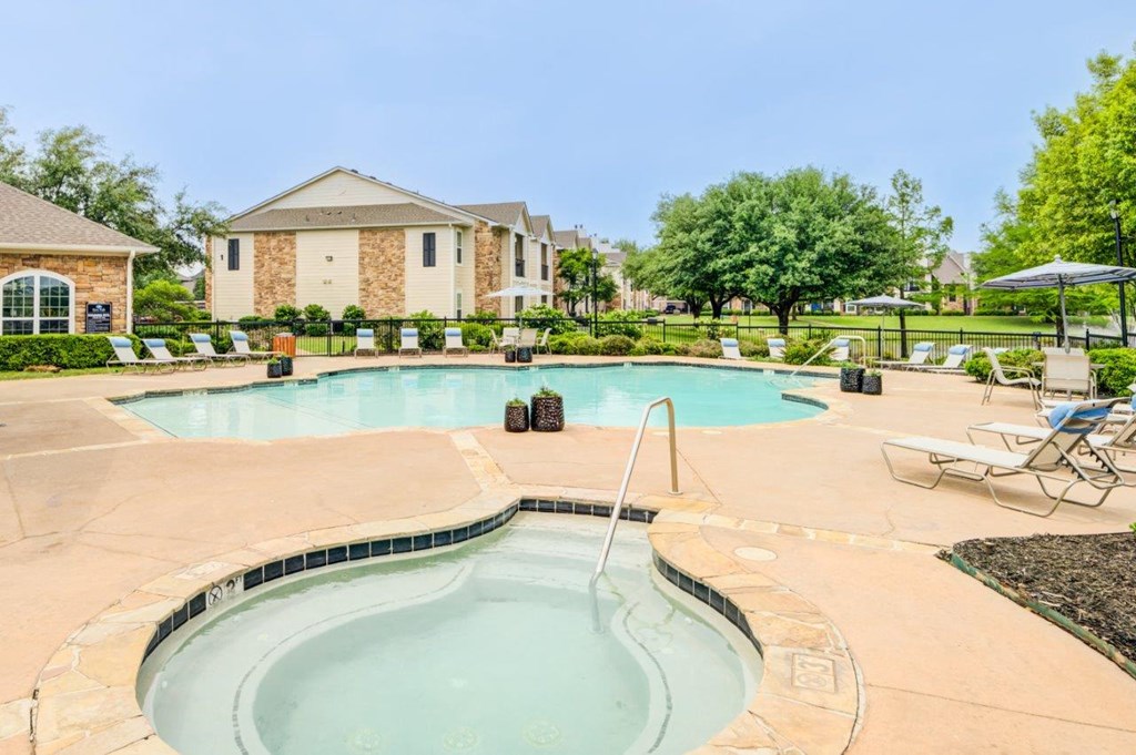 a swimming pool with chairs and a house in the background
