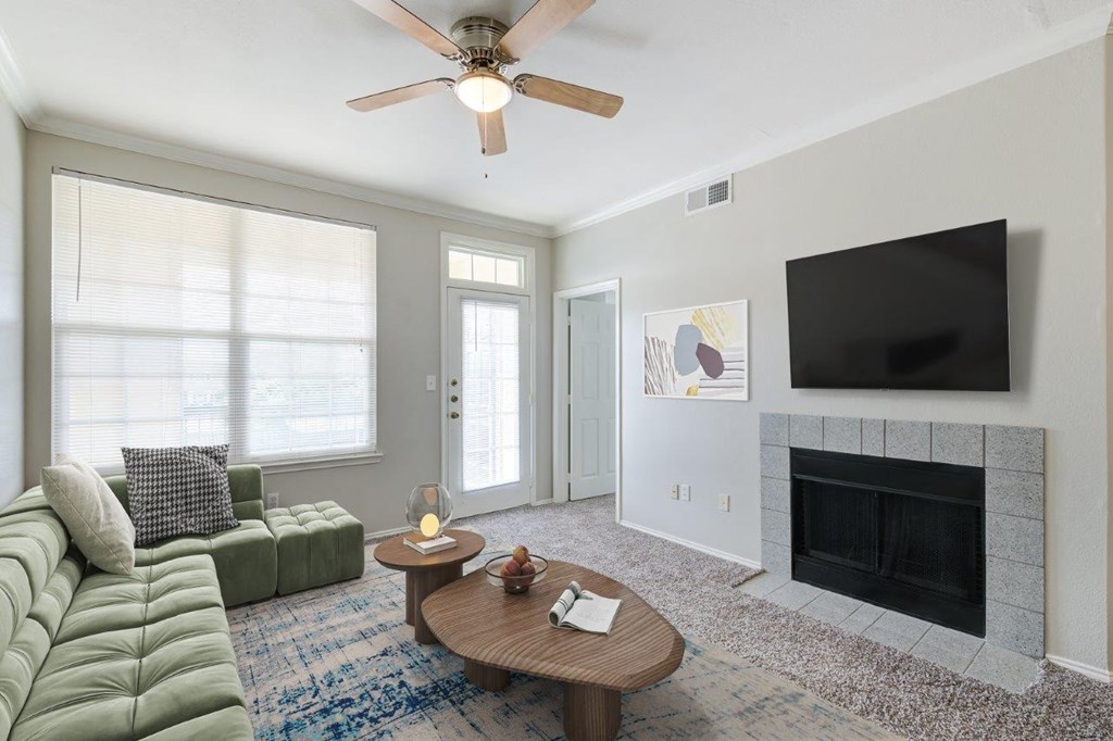 a living room with a ceiling fan and a television