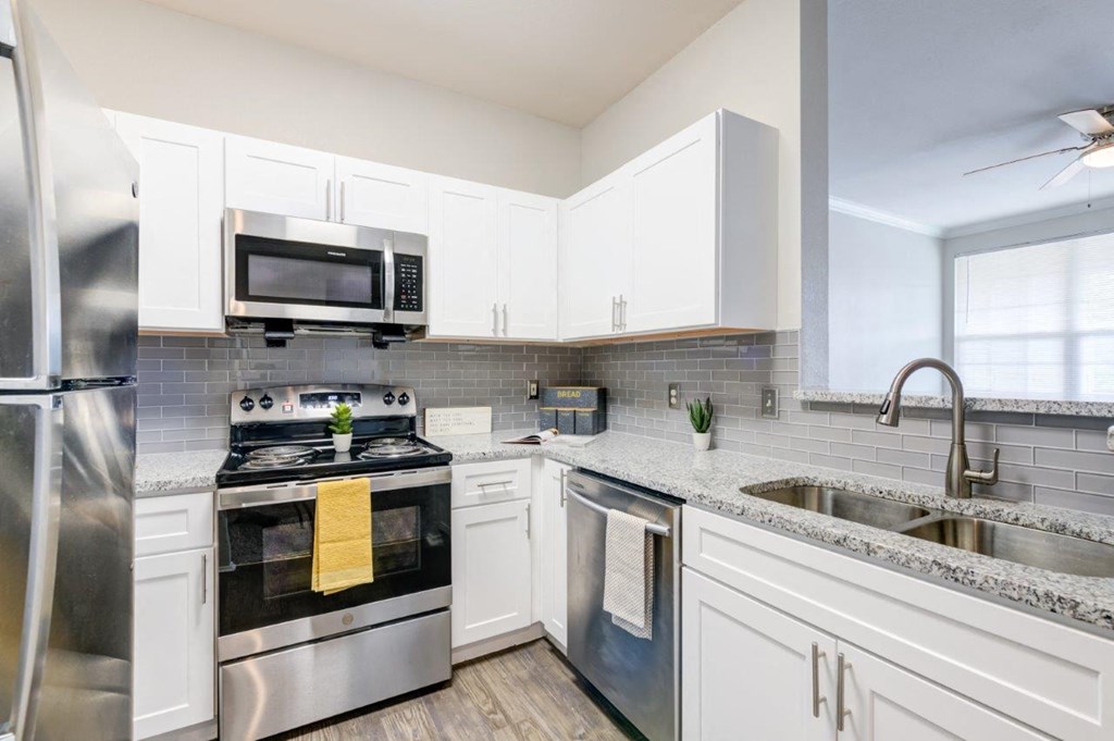 a kitchen with stainless steel appliances and white cabinets