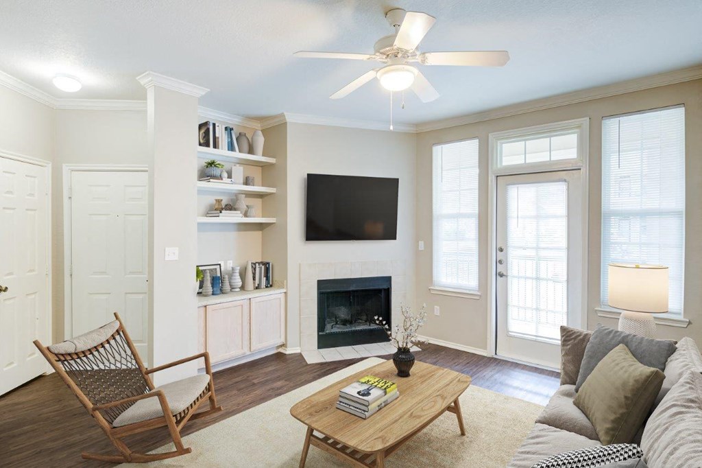 a living room with a fireplace and a ceiling fan