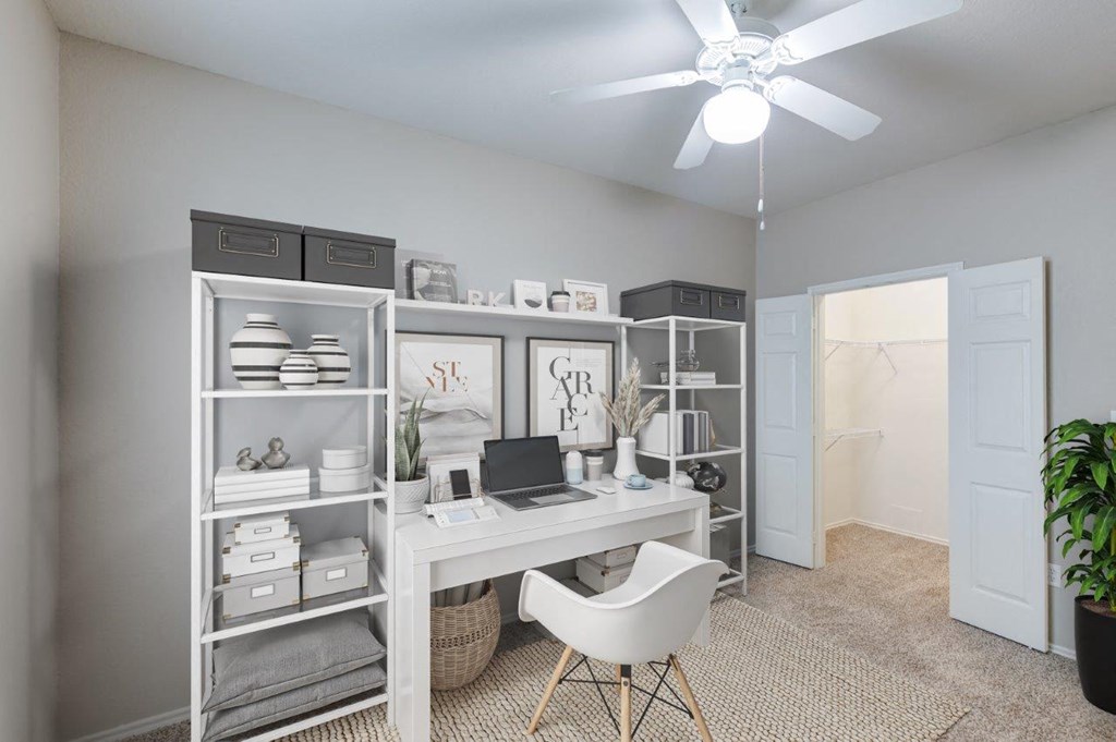 an office with a desk and a ceiling fan
