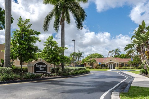 a street in front of a building with palm trees
