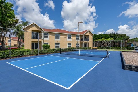 a tennis court with a house in the background