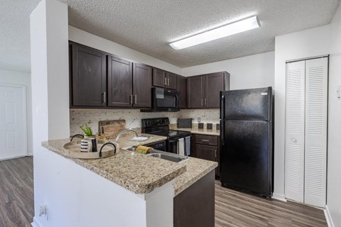 a kitchen with black appliances and granite counter tops