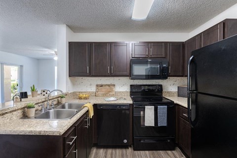 a kitchen with black appliances and granite counter tops