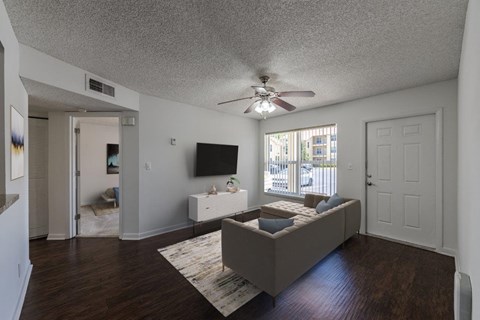 a living room with a couch and a ceiling fan