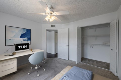 a bedroom with a closet and a ceiling fan