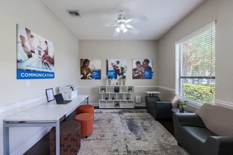 an office with couches and a desk and a large window