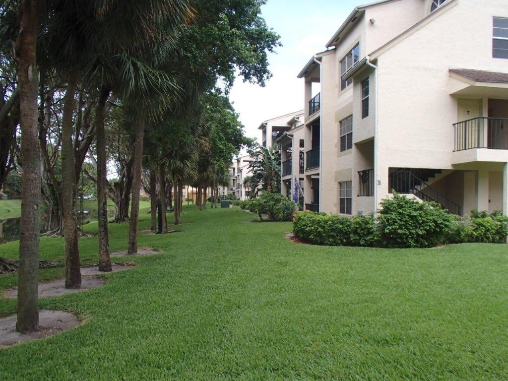 a lush green yard in front of some apartments