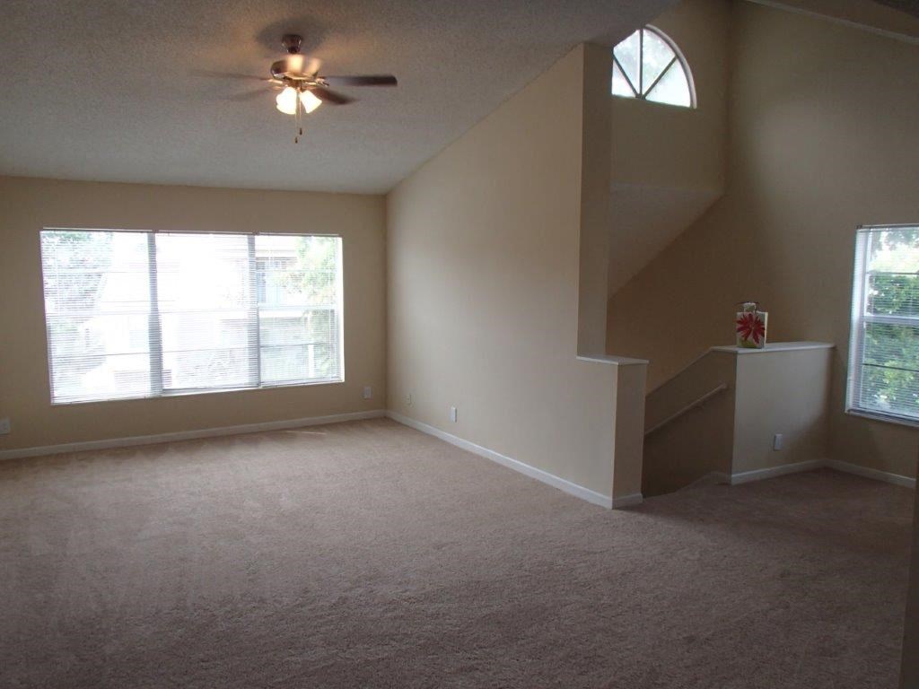 a living room with a ceiling fan and a large window