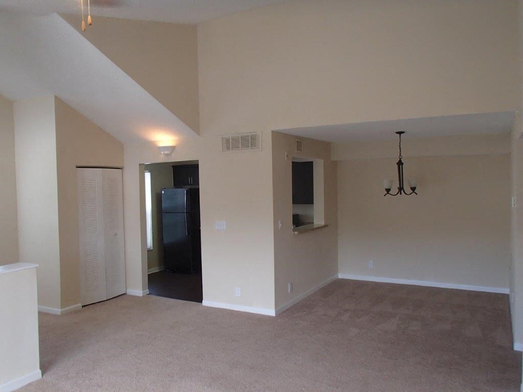 an empty living room with a chandelier
