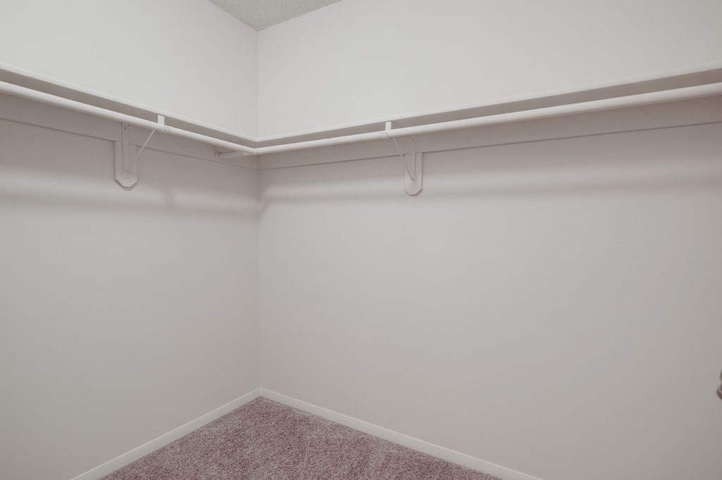 an empty room with white walls and white hangers on the wall